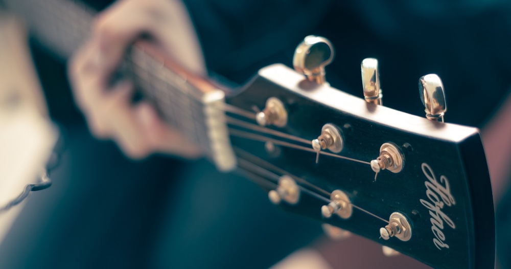 main gauche sur manche guitare flouté